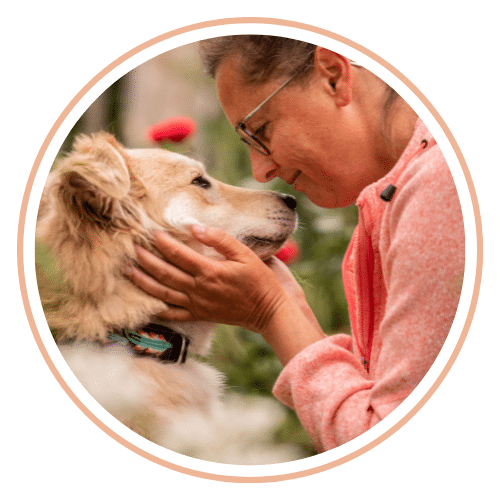 Eine harmoische Mensch Hund Beziehung zwischen einer Frau und ihrem Hund in inniger Umarmung
